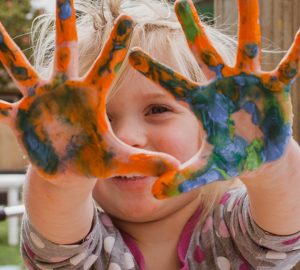 child with finger paint on hands