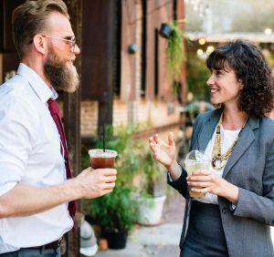 man and woman talking on sidewalk